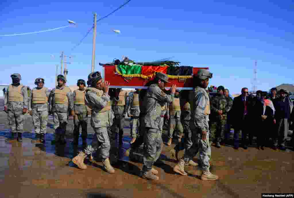 Afghan border police carry the coffin of an Afghan victim killed on Ukrainian Airlines flight PS752, which crashed near Tehran, at Islam Qala on the outskirts of Herat near the border between Afghanistan and Iran on January 17. (AFP/Hoshang Hashimi)