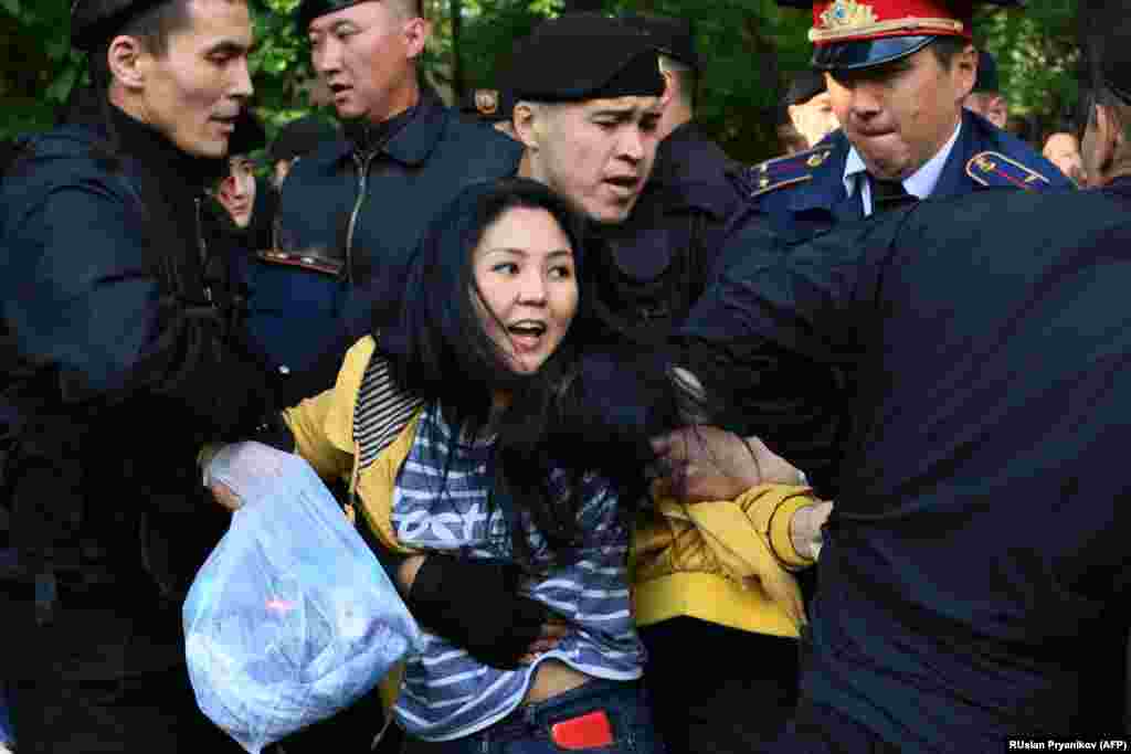 Kazakh police officers detain opposition protesters in Almaty on May 1. (AFP/Ruslan Pryanikov)