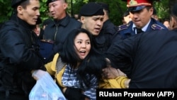 Kazakh police officers detain opposition protesters in Almaty on May 1.