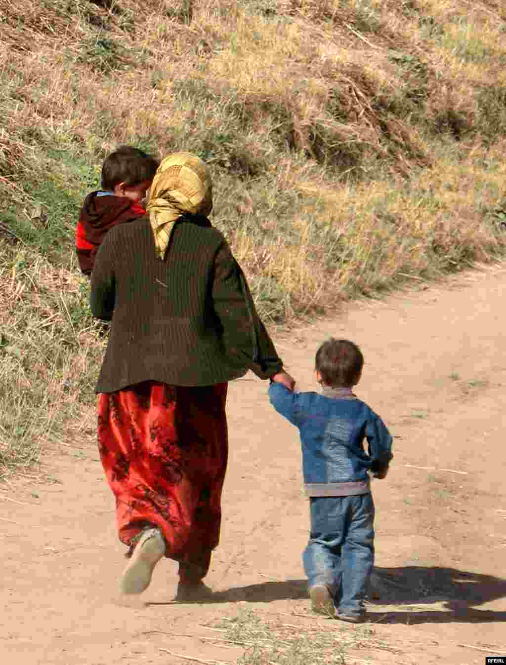 Tajikistan -- woman w/ children (vert) in eastern Tajik village of Chormaghz; Sept 2008 (photo for RFE/RL Tajik Service by Munavvar Munavvarzad) - Tajikistan -- woman w/ children (vert) in eastern Tajik village of Chormaghz; Sept 2008 (photo for RFE/RL Tajik Service by Munavvar Munavvarzad)