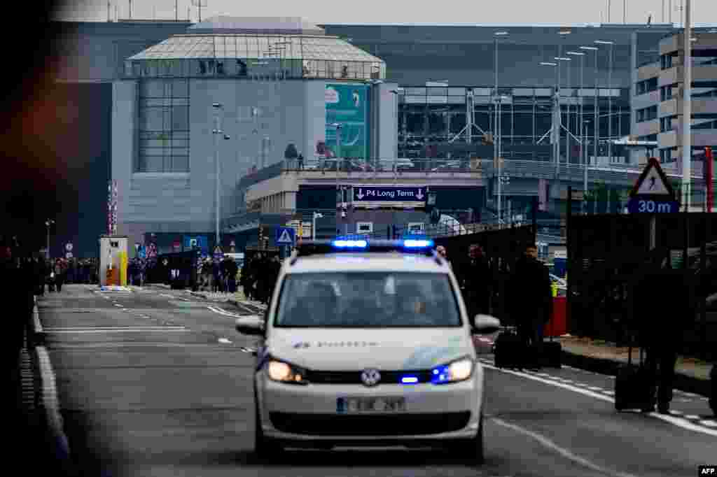 Policija i putnici pored aerodroma nakon eksplozija