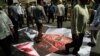 Iranians walk over a picture of U.S. President Barack Obama following the weekly Friday Prayer ceremony in Tehran. (AFP/Atta Kenare)