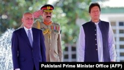 Afghan President Ashraf Ghani (left) and Pakistani Prime Minister Imran Khan (right) review an honor guard during a welcoming ceremony in Islamabad on June 27.