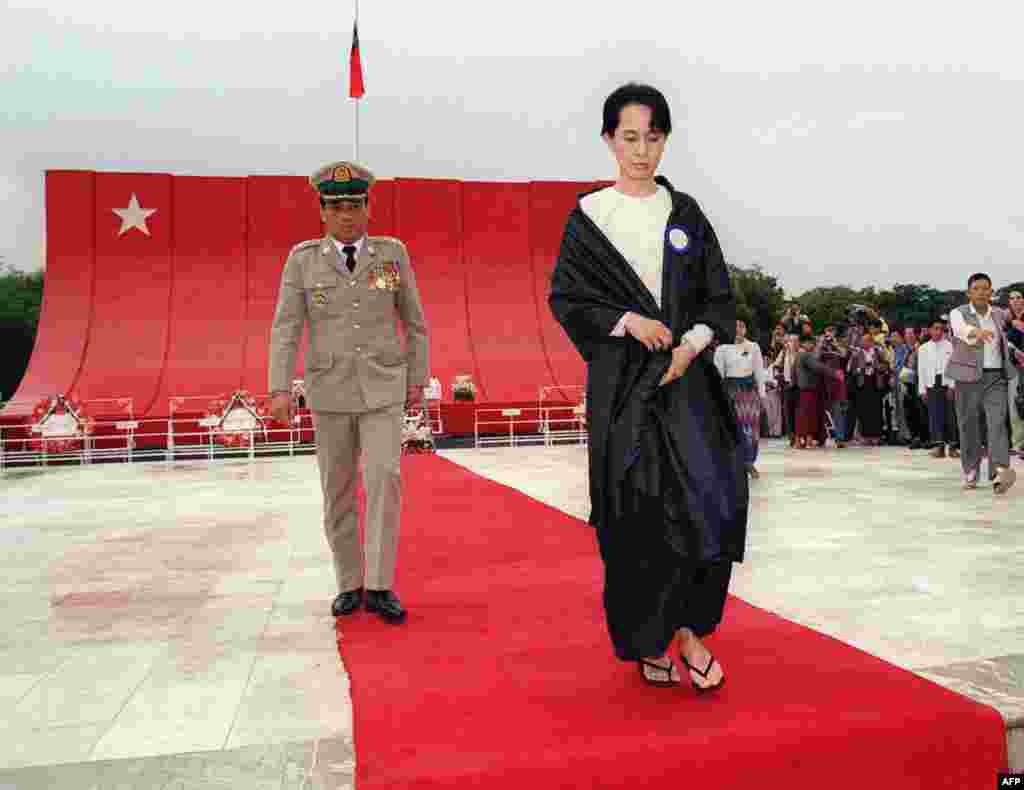 Aung San Suu Kyi, followed by Lieutenant Colonel Than Tun from the Myanmarese government, lays a bouquet of flowers at the tomb of her assassinated father, Burmese liberation hero Aung San, on Martyr's Day in Yangon in 1995.