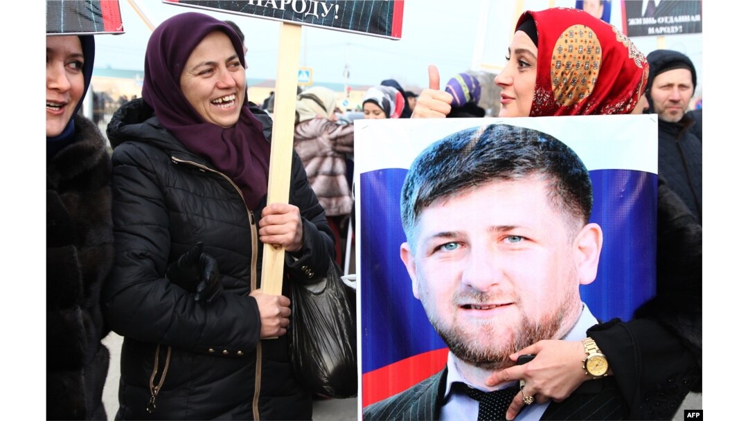 A Chechen woman holds a picture of Ramzan Kadyrov during a rally in central Grozny last month.