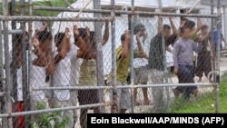 Asylum seekers stand behind a fence at the Australian-run Manus Island detention center in Papua New Guinea. (file photo)