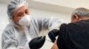 AstraZeneca фирмасының коронавирусқа қарсы шығарған Vaxzevria екпесін салдырып отырған адам. Ташкент, 1 сәуір 2021 жыл.