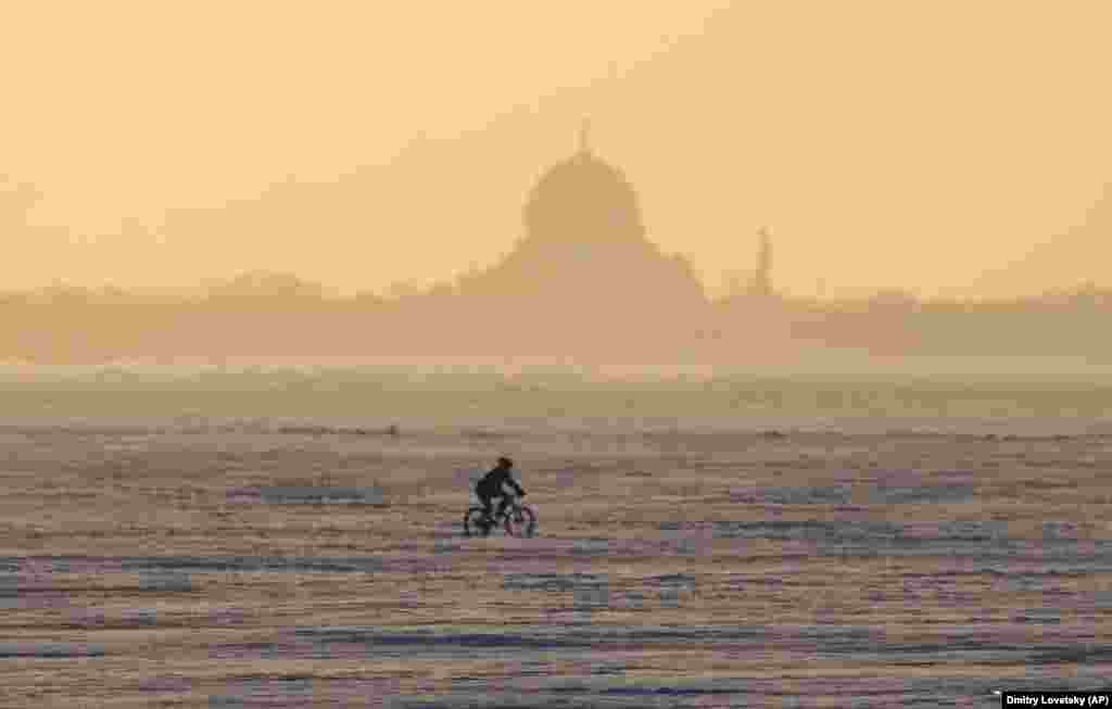 A man rides a bike across the frozen Finnish Gulf outside St. Petersburg. (AP/Dmitry Lovetsky)