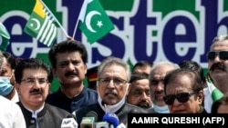 Pakistani President Arif Alvi (C) speaks, along with other leaders, during a rally organized to show their solidarity with people of Indian-administered Kashmir, on a street in Islamabad on August 5.