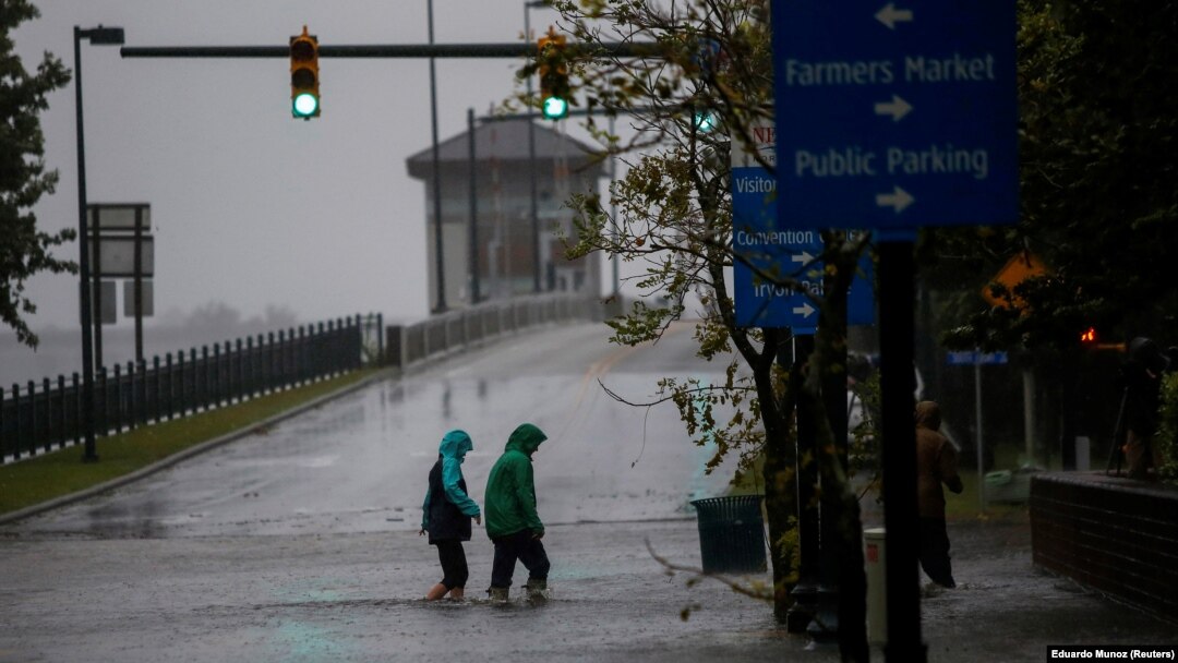 People walk on a local street as water from Neuse River starts flooding houses upon Hurricane Florence coming ashore in New Bern, North Carolina, U.S., September 13, 2018. REUTERS/Eduardo Munoz