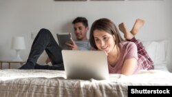 Belarus Portrait of an happy couple using a laptop computer in their house