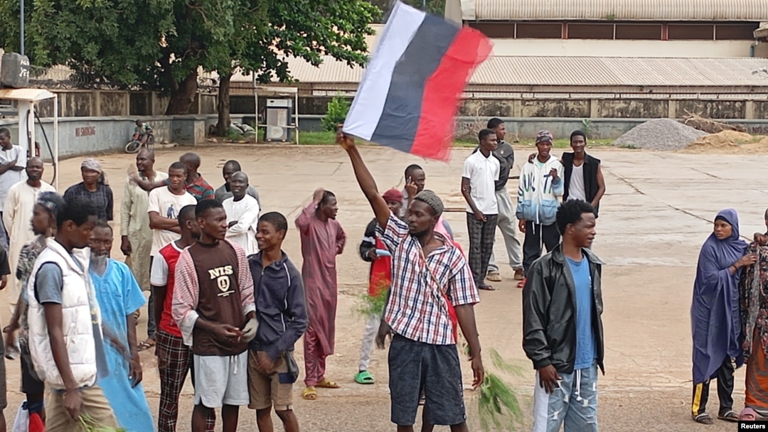O demonstrație în care un bărbat ține în mână un steag rusesc în statul Kaduna, din nordul Nigeriei, pe 5 august 2024.