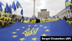 Ukraine – Activists of Ukrainian movement "For European Future" hold EU flag with the Ukraine national emblem during their rally at Independence Square in Kyiv on October 30, 2013