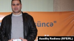 Şamaxıda Şəhidlər Xiyabanının dağılmış vəziyyətini əks etdirən videonun müəllifi Fariz Babayev AzadlıqRadiosunun Bakı bürosunda hədiyyəsini qəbul edərkən. 1 mart 2013