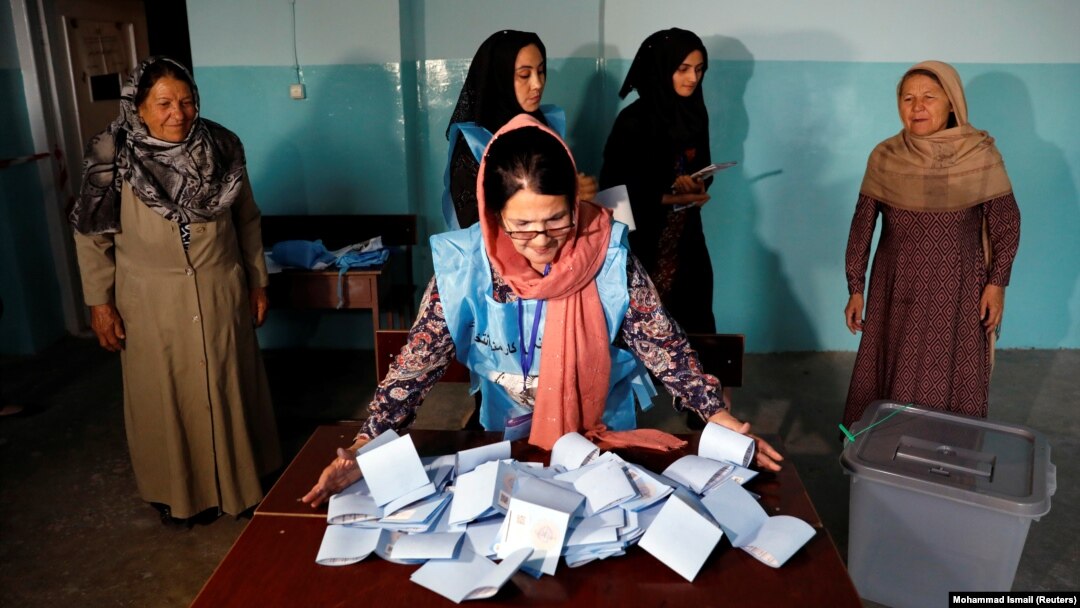 An Afghan election commission worker prepares ballot papers for counting in Kabul.