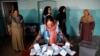 An Afghan election commission worker prepares ballot papers for counting after voting ended on September 28.