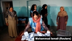 An Afghan election commission worker prepares ballot papers for counting after voting ended on September 28.