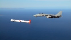 US -- A Tactical "Tomahawk" Block IV cruise missile is escorted by a Navy F-14 