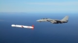 US -- A Tactical "Tomahawk" Block IV cruise missile is escorted by a Navy F-14 