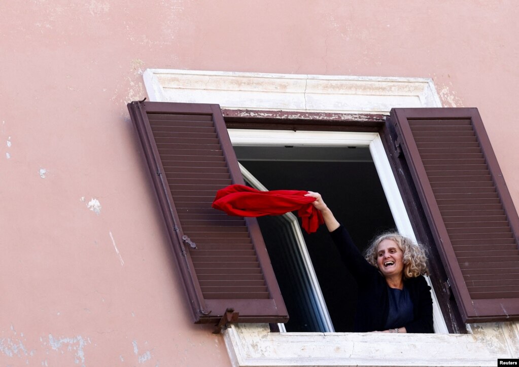 Një grua duke valëvitur një rrobë të kuqe gjatë një demonstrate në Romë, Itali.