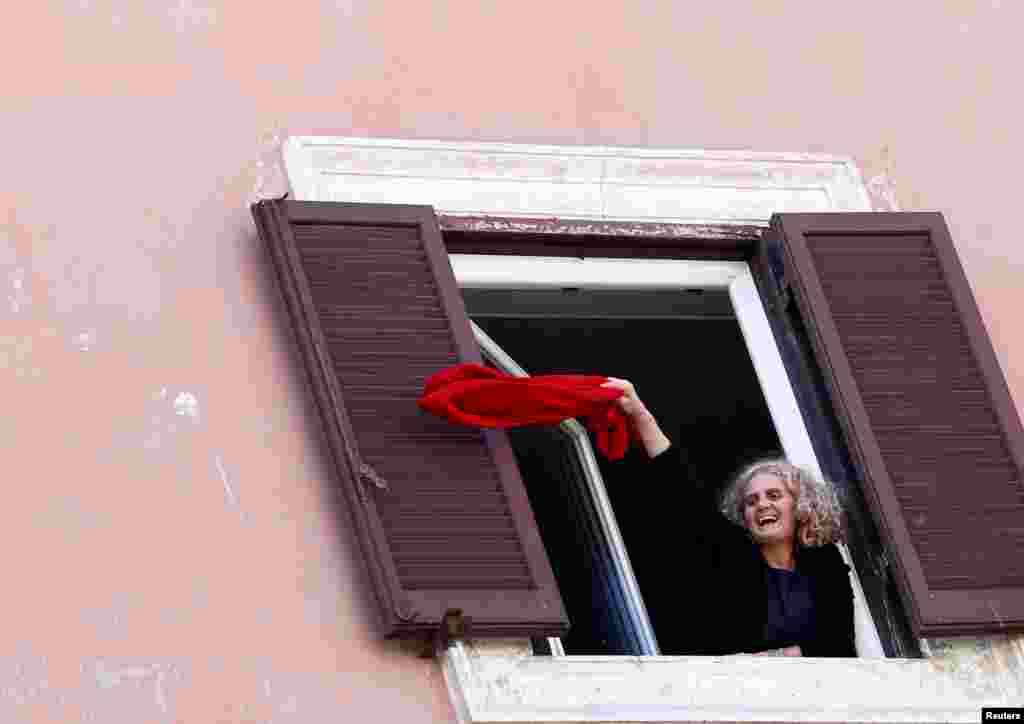 Një grua duke valëvitur një rrobë të kuqe gjatë një demonstrate në Romë, Itali.