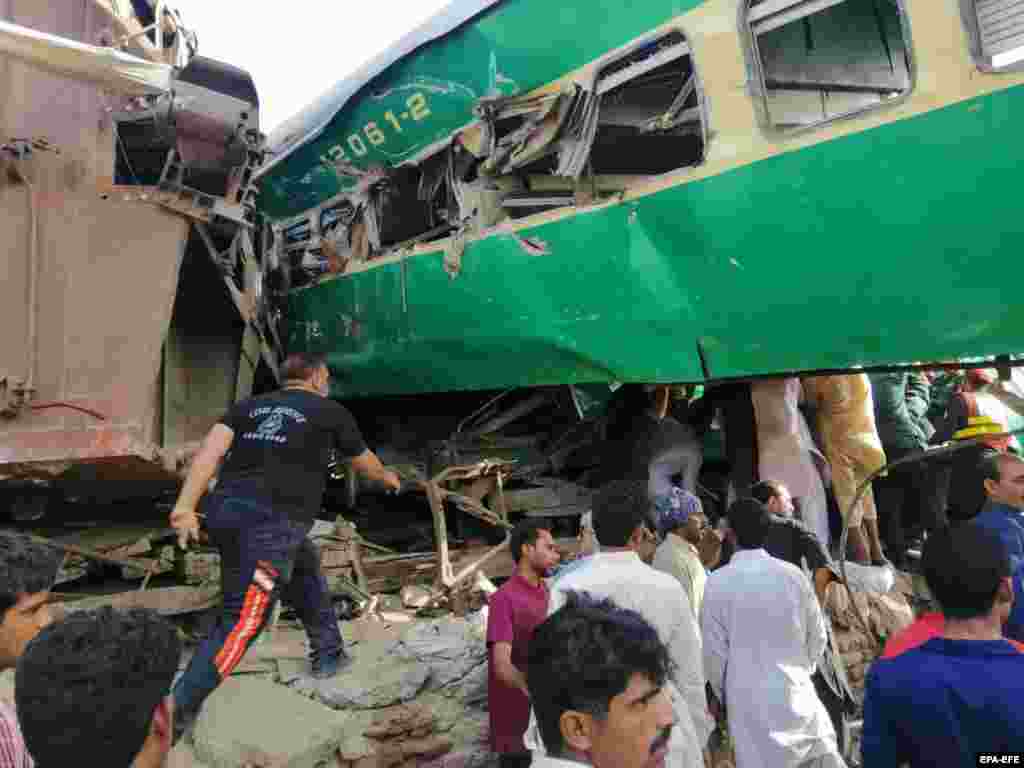 People gather at the scene of a train accident near Sadiqabad, July 11, 2019. 