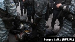 Бойцы Беркута собираются грузиться в автобусы на Крещатике возле Европейской площади. На земле лежат один убитый (пулевое ранение в голову) и один раненый из бойцов их роты. Фото Сергея Лойко.