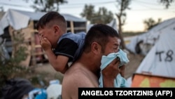 A man and boy react after police fired tear gas during clashes outside the Moira migrant camp on the Greek island of Lesbos on September 29.