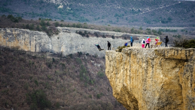 Вслед за товарищем к прыжку с «крыши» пещерного города Качи-Кальон готовится второй парашютист | Крымское фото дня