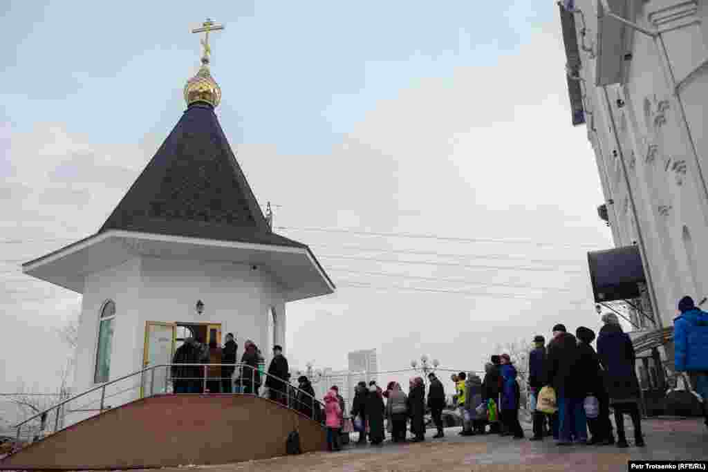 С раннего утра во дворе Богоявленского храма, неподалеку от Сайрана, выстроилась длинная очередь: люди приходят за святой водой. Алматы, 19 января 2019 года.