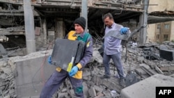 People in Tehran retrieve computer servers and equipment from an office building that housed the offices of the Doha-headquartered news network Al Araby TV following a missile strike on the Iranian capital on March 29. 