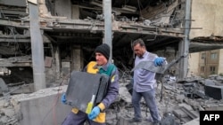 Ljudi u Teheranu izvlače računarske servere i opremu iz poslovne zgrade u kojoj su se nalazile kancelarije informativne mreže Al Araby TV sa sjedištem u Dohi nakon raketnog napada na iransku prijestolnicu 29. marta.