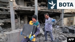 Njerëzit në Teheran marrin serverë kompjuterikë dhe pajisje nga një ndërtesë zyrash që kishte strehuar zyrat e rrjetit mediatik Al Araby TV me seli në Doha, pas një sulmi me raketa në kryeqytetin iranian më 29 mars.