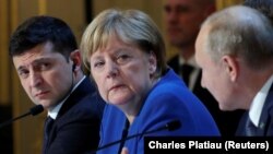 Ukraine's President Volodymyr Zelenskiy and German Chancellor Angela Merkel listen to Russia's President Vladimir Putin as they attend a joint news conference in Paris on December 10.