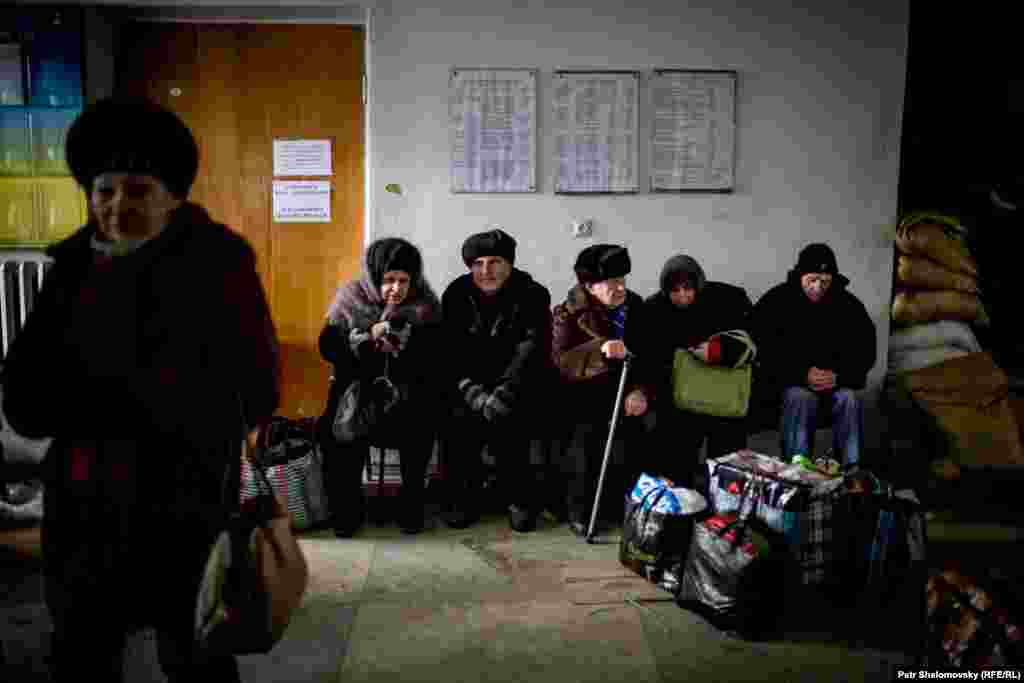 People wait for evacuation assistance at the damaged city council building.