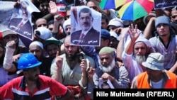 Supporters of the deposed Egyptian President Muhammad Morsi wave his portrait in a protest near the Rabia al-Adawiya Mosque in Cairo on August 1.