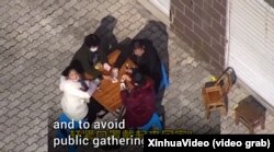 Поліцейський дрон заганяє до приміщення компанію, яка грає у карти на дворі. Китай, лютий 2020 року