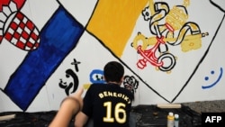 Хорватия, 2011 г. Молодой человек рисует граффити на тему хорватского и папского флагов еще до отречения Папы Бенедикта XVI