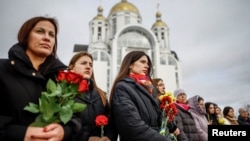Oamenii aduc flori în memoria victimelor atacurilor și execuțiilor făcute de trupele rusești, Bucea, regiunea Kiev - 24 februarie 2026