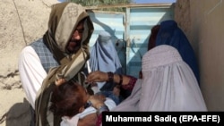 An Afghan health worker administers a polio vaccinates to a child in Kandahar earlier this year.