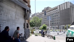 Members of Iranian security forces looking at the parliament building in central Tehran.