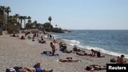 Отдыхающие на пляже в окрестностях Афин, Греция. Апрель 2021 года.