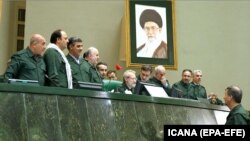 Iranian lawmakers wearing Iranian Revolutionary Guard Corps (IRGC) official uniforms gather around parliament speaker Ali Larijani (top, C) at the Iranian parliament in Tehran, April 9, 2019