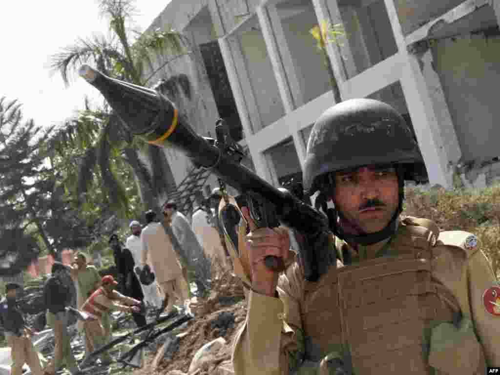 Pakistan -- Security officials and rescuers gather at a bomb blast site in Peshawar, 23Oct2009 - PAKISTAN, Peshawar : Pakistani security officials and rescuers gather at a bomb blast site in Peshawar on October 23, 2009. Bombers targeted an air force base and later an upmarket restaurant in Pakistan, unleashing fresh bloodshed in a 19-day wave of attacks that has left nearly 200 people dead.