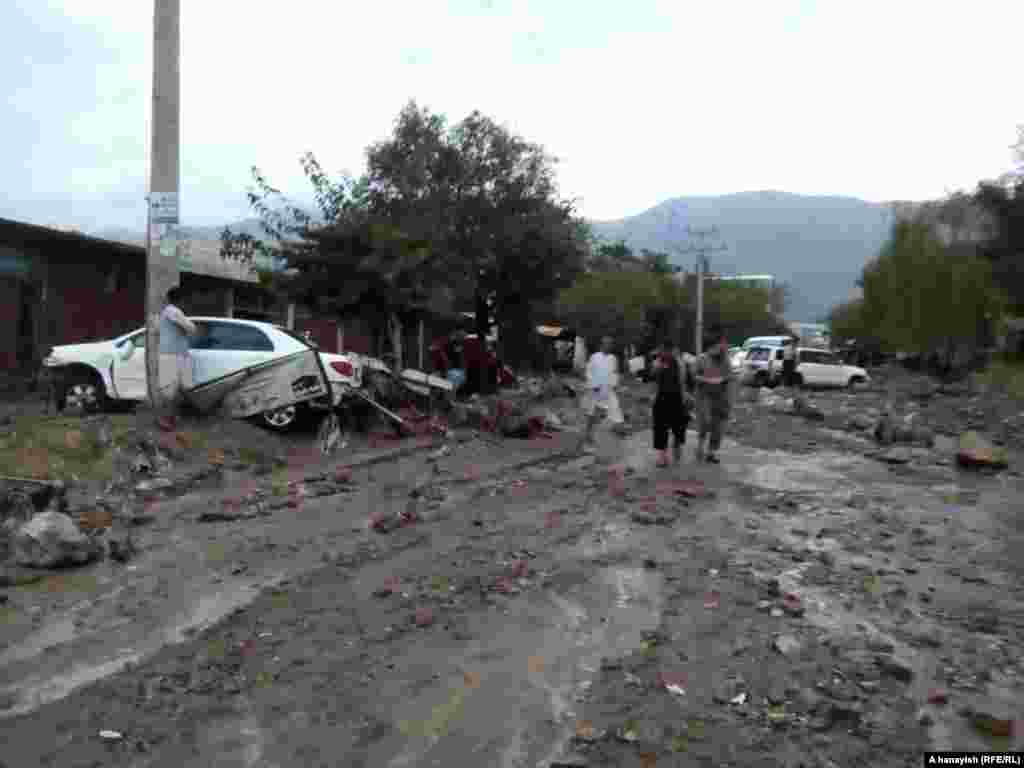 Vehicles are strewn across a mud-filled street in Charikar.