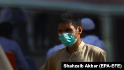 A man wears a face mask on a road during a renewed lockdown after new cases of COVID-19 were reported, in Karachi, earlier this month. 