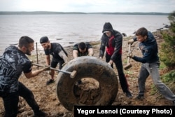 Önkéntesek az irkutszki tározóból kihúzott abroncsokat tisztítanak