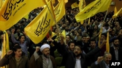 Members the Islamic hard-line Basiji volunteer militia hold flags reading "Down with the U.S.A." as they take part in a protest against America inside the former U.S. embassy in Tehran on November 2.
