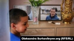 Сын Сервера Мустафаева Юнус возле фотографии отца в своем доме