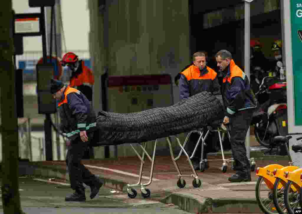 Санитары &quot;скорой помощи&quot; выносят тело одного из погибших при взрыве на станции метро &quot;Мальбек&quot;. 22 марта 2016 года.